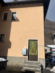 ein Gebäude mit einer Tür und einer Treppe davor in der Unterkunft Casa Pesa - Olivone in Olivone + 3 Fotos