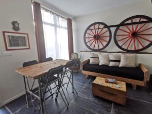 a living room with a table andokedoked wheels on the wall at Exclusivité - La Maison à Vapeur avec climatisation in Nantes