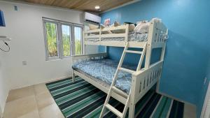 two bunk beds in a room with a blue wall at 8 Bedroom Ocean Front in Eleuthera Double Bay with pool in Savannah Sound +93 photos