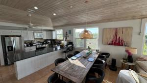 a kitchen with a wooden table and some chairs at 8 Bedroom Ocean Front in Eleuthera Double Bay with pool in Savannah Sound