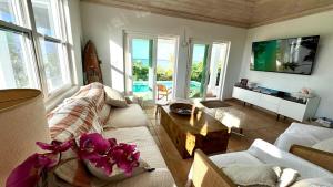 a living room with a couch and a table at 8 Bedroom Ocean Front in Eleuthera Double Bay with pool in Savannah Sound