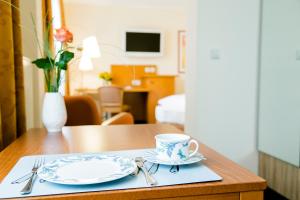 einen Tisch mit zwei Tellern und einer Kaffeetasse darauf. in der Unterkunft Hotel Möhringer Hof in Stuttgart