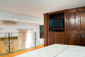 a bedroom with a bed and a dresser with a television at Baroque Residence in Timişoara