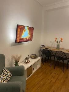 un soggiorno con tavolo e TV a parete di Casa Vera, vistas en el corazon de la ciudad ad Antequera