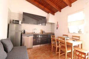 una cucina e una sala da pranzo con tavolo e frigorifero di Sentinela Place a Azinhal