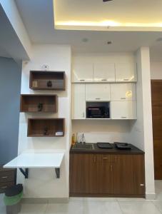 een keuken met witte kasten en een aanrechtblad bij Eden Suite in Noida