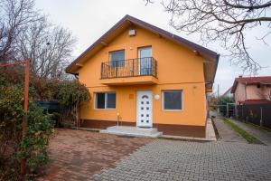 a yellow house with a balcony on top of it at Casa Andrea in Otopeni