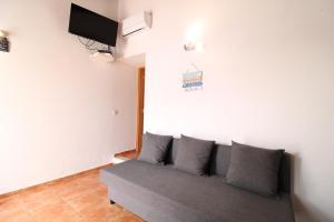 un divano in camera con TV a parete di Sentinela Place a Azinhal