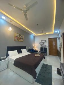 een slaapkamer met een groot bed met een plafondventilator bij Eden Suite in Noida
