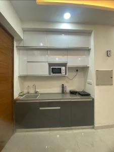 een keuken met een spoelbak en een magnetron bij Eden Suite in Noida +2 foto's