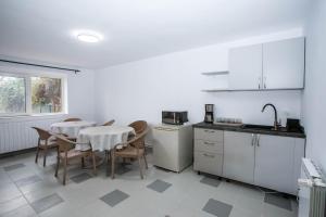 una cucina con un tavolo e sedie in una stanza di Casa Andrea a Otopeni