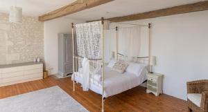 ein Schlafzimmer mit einem Himmelbett und einem Holzboden in der Unterkunft Le Font remy in Mortagne-sur-Gironde + 35 Fotos