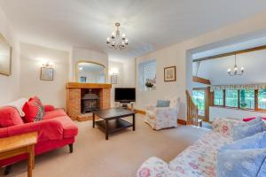 ein Wohnzimmer mit einem roten Sofa und einem Kamin in der Unterkunft 3 Bed in Hartfield oc-tw653 in Hartfield