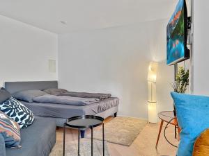 a living room with two beds and a couch at Stgt Gartenwohnung mit Patio - 4 Personen in Stuttgart