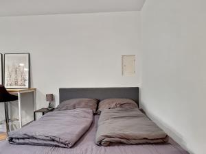 a bed with pillows on it in a bedroom at Stgt Gartenwohnung mit Patio - 4 Personen in Stuttgart