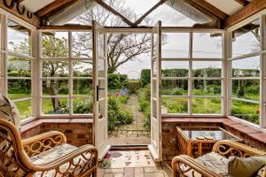 an empty conservatory with windows and a view of a garden at 3 Bed in Rumburgh oc-c27094 in Rumburgh