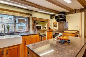 a large kitchen with wooden cabinets and a counter top at 3 Bed in Rumburgh oc-c27094 in Rumburgh +12 photos