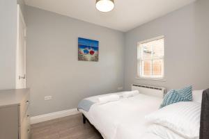 ein Schlafzimmer mit einem weißen Bett und einem Fenster in der Unterkunft Nr 8 - Modern 2 Bed Flat - WiFi - Town Centre - Parking in Bedford