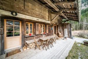 a wooden cabin with a table and chairs on a deck at LA FERME D'AGATHE in Abondance
