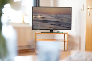 een flatscreen-tv op een stand in een kamer bij Tuttelduven in Bisdorf