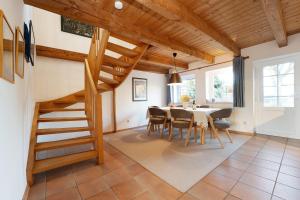 een eetkamer met een trap en een tafel en stoelen bij Tuttelduven in Bisdorf +32 foto's