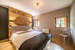 a bedroom with a large bed and a chair at LA FERME D'AGATHE in Abondance
