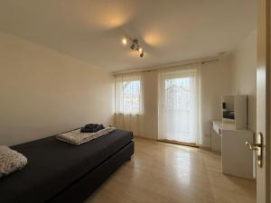 a bedroom with a bed and a tv and a window at Haus Raschke in Schongau