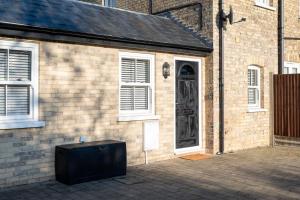 Ein Fernseher steht vor einem Backsteingebäude mit einer Tür. in der Unterkunft Nr 8 - Modern 2 Bed Flat - WiFi - Town Centre - Parking in Bedford