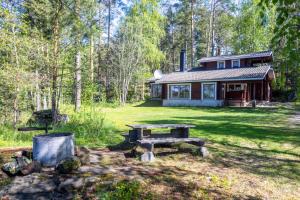 een huis met een picknicktafel ervoor bij Mökki Syrjälä in Puumala