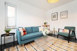 een woonkamer met een blauwe bank en twee stoelen bij Gerberhof 1 in Plön