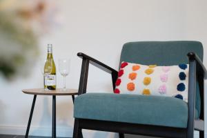 een groene stoel met een kussen en een fles wijn bij Gerberhof 1 in Plön