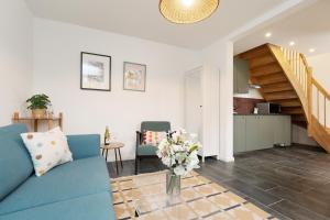 een woonkamer met een blauwe bank en een keuken bij Gerberhof 1 in Plön +27 foto's