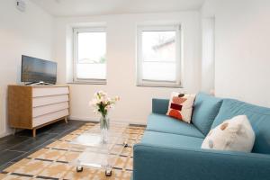 een woonkamer met een blauwe bank en een tv bij Gerberhof 1 in Plön