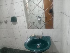 een groen toilet in een badkamer met een spiegel bij Pirqainn in Puno