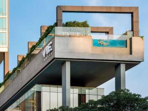 a building with a swimming pool on top of it at VIE Hotel Bangkok - MGallery Collection in Bangkok
