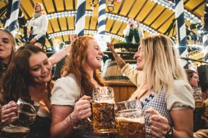 a group of women drinking beer in a pub at Munich Oktoberfest Bavarian Camping Village with breakfast & welcome beer in Munich