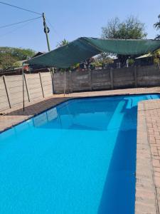 una piscina blu con una recinzione e acqua blu di Protea Guesthouse a Phalaborwa