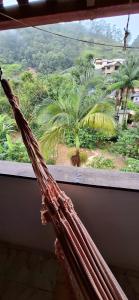 una finestra con vista su una palma di Casa Flor 2- Centro vista p o Rio a Nova Friburgo Altre 7 foto