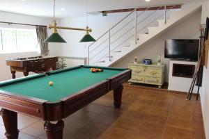 een woonkamer met een pooltafel en een trap bij Paço AL in Monção