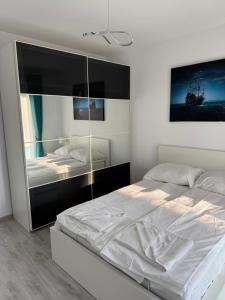 a bedroom with a large white bed and a mirror at Modern Stay in Şelimbăr
