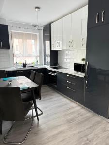 a kitchen with black and white cabinets and a table at Modern Stay in Şelimbăr