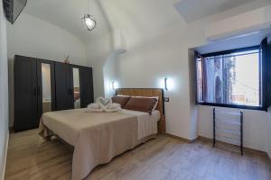 una camera da letto con un letto e una grande finestra di Costa Apartment a Catania