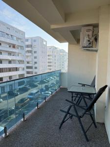a table and chair on a balcony with a view of a city at Modern Stay in Şelimbăr