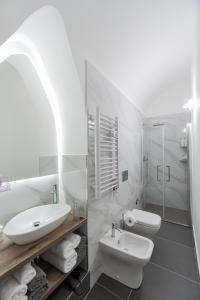 un bagno bianco con lavandino e WC di Costa Apartment a Catania Altre 8 foto
