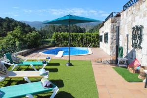 een zwembad met 2 ligstoelen en een parasol bij Paço AL in Monção