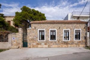 a stone building with white windows on a street at Seaside Stone Retreat in Salamina
