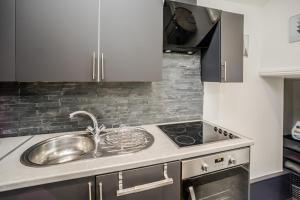 een keuken met een spoelbak en een fornuis bij Cottage hide-out in Kirkheaton