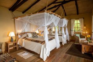 a bedroom with a canopy bed in a room at Virunga Lodge in Nkumba