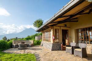 a house with a patio with mountains in the background at Virunga Lodge in Nkumba