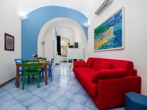 a living room with a red couch and a table at Ficus Home - De Vivo Realty in Sant'Agnello